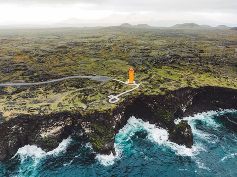 View of orange Svortuloft Lighthouse by the sea in West Iceland highlands, Snaefellsnes peninsula, View Point near Svortuloft Lighthouse. Spectacular black volcanic rocky ocean coast with cave arch and towers. High quality photo