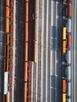 Cargo trains close-up. Aerial view of colorful freight trains on the railway station. Wagons with goods on railroad. Heavy industry. Industrial conceptual scene with trains. Top view from flying drone. High quality photo