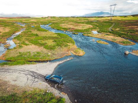 Car driving across the water somewhere in Iceland inland. Flooded roads in Iceland. Car driving trough water. Extreme conditions.