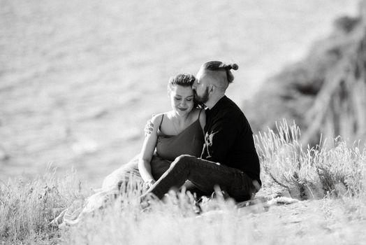 pregnant girl and boyfriend on high hills near the sea