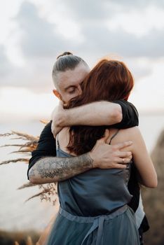 wedding ceremony of a girl and a guy on high hills near the sea