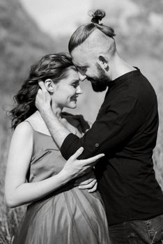 pregnant girl and boyfriend on high hills near the sea