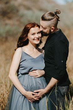 pregnant girl and boyfriend on high hills near the sea