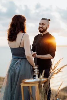 wedding ceremony of a girl and a guy on high hills near the sea