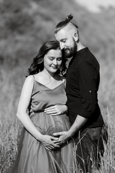 pregnant girl and boyfriend on high hills near the sea