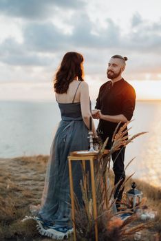 wedding ceremony of a girl and a guy on high hills near the sea