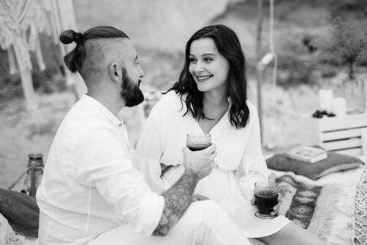 pregnant girl and boyfriend on a picnic by the sea in white clothes