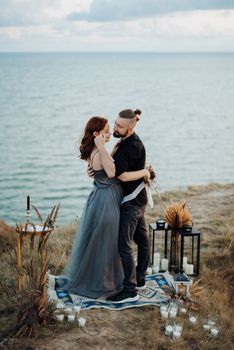 wedding ceremony of a girl and a guy on high hills near the sea