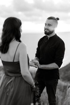 wedding ceremony of a girl and a guy on high hills near the sea