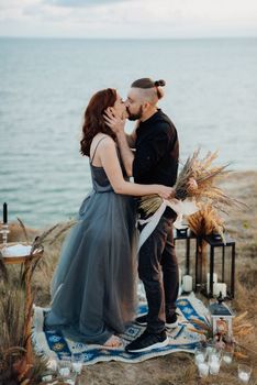 wedding ceremony of a girl and a guy on high hills near the sea