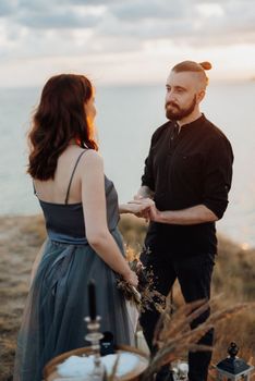 wedding ceremony of a girl and a guy on high hills near the sea