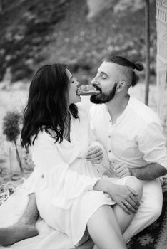 pregnant girl and boyfriend on a picnic by the sea in white clothes