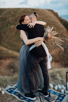 wedding ceremony of a girl and a guy on high hills near the sea