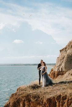 pregnant girl and boyfriend on high hills near the sea