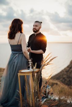 wedding ceremony of a girl and a guy on high hills near the sea