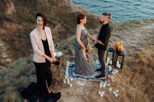 wedding ceremony of a girl and a guy on high hills near the sea