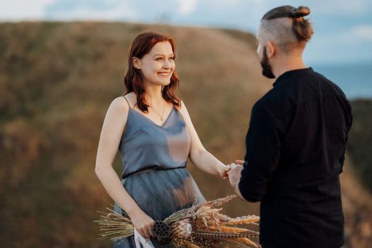 wedding ceremony of a girl and a guy on high hills near the sea