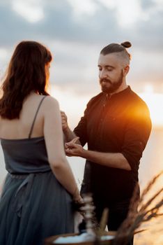 wedding ceremony of a girl and a guy on high hills near the sea