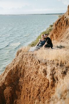 pregnant girl and boyfriend on high hills near the sea