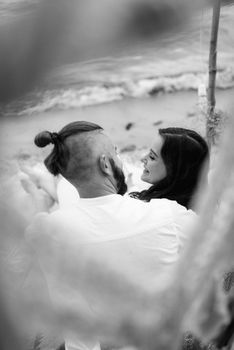 pregnant girl and boyfriend on a picnic by the sea in white clothes