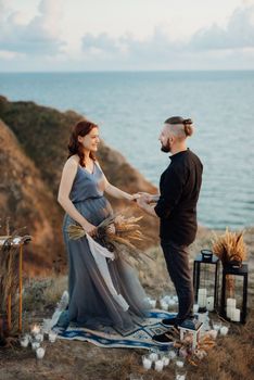 wedding ceremony of a girl and a guy on high hills near the sea