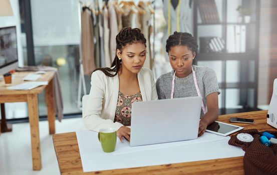 Theyre working on a new brand. two young fashion designers working on a laptop