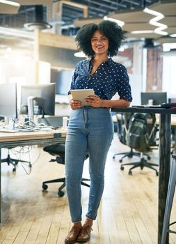 She loves how technology helps her stay organized. a young female designer working in her office