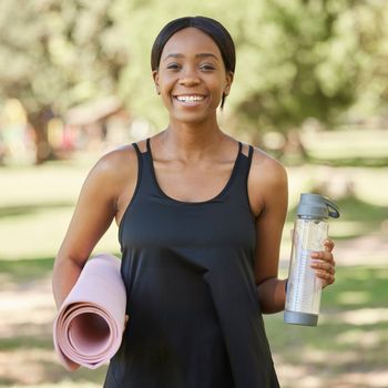 Portrait of black woman in park with yoga mat and water bottle, smile in nature for health and fitness mindset. Exercise, zen and yoga, happy woman ready for pilates workout on grass in summer sun