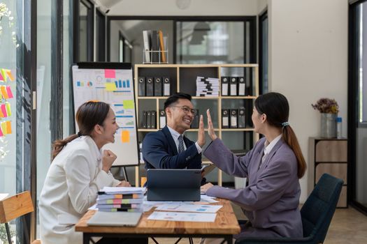 Group of Young Asian business team creative businesspeople coworker in office Happy to be successful partnership teamwork celebrating achievement and success concept.