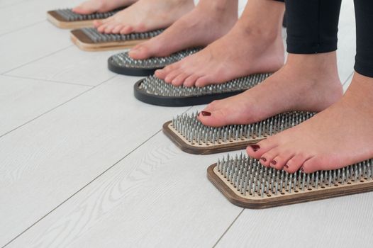 Close-up of three women's feet on sadhu's nails