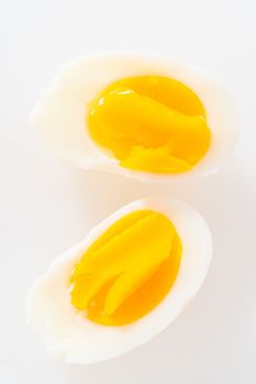 Slicing hard-boiled eggs on a white cutting board.