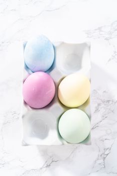 Colored hard-boiled eggs on a marble background.