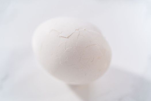 Peeling hard-boiled eggs at the marble kitchen counter.