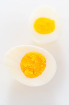 Slicing hard-boiled eggs on a white cutting board.