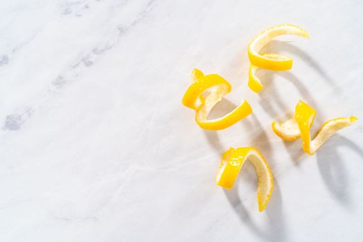 Preparing lemon swirls from the organic lemon to decorate the cocktail.
