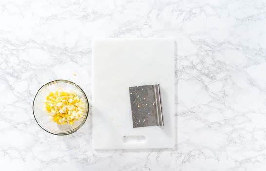 Flat lay. Cutting hard-boiled eggs in a shape of a loaf on a white cutting board.