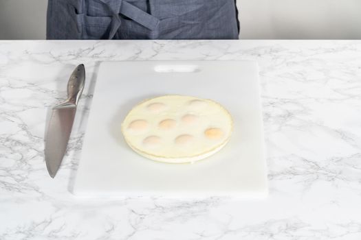 Cutting hard-boiled eggs in a shape of a loaf on a white cutting board.