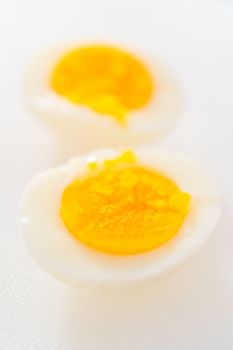 Slicing hard-boiled eggs on a white cutting board.