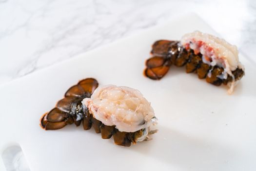 Preparing raw lobster tails to make garlic lobster tails.