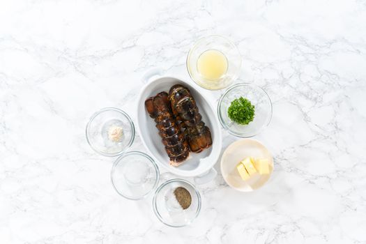 Flat lay. Measured ingredients in glass mixing bowls to prepare garlic lobster tails.