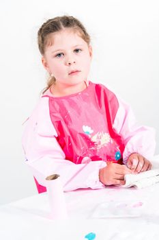 Little girl making a unicorn out of the toilet paper roll and craft paper.