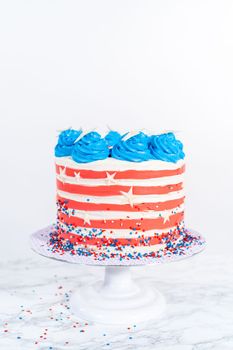 Decorating chocolate cake with white, red, and blue buttercream frosting for July 4th celebration.