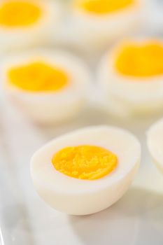 Sliced hard-boiled eggs on a white serving plate.