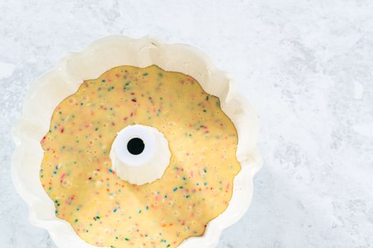 Cake batter in a bundt cake pan to bake funfettti bundt cake.