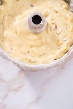 Cake batter in a bundt cake pan to bake apple bundt cake with caramel glaze.