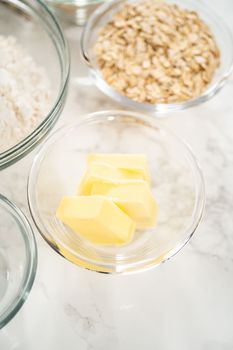 Measured ingredients in glass mixing bowls to bake banana oatmeal muffins.