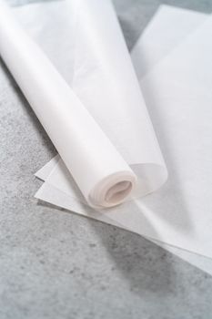 Pre-cut and rolled parchment papers on the kitchen counter.