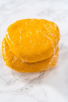 Lemon wedge cookies with lemon glaze. Wrapping cookie dough for chilling in the refrigerator to bake lemon wedge cookies with lemon glaze.