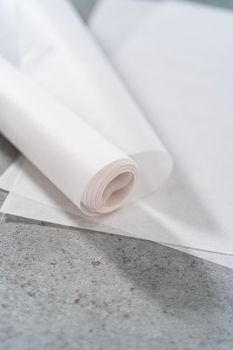 Pre-cut and rolled parchment papers on the kitchen counter.