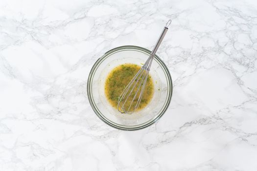 Flat lay. Mixing ingredients in a glass mixing bowl to prepare butter mixture for garlic lobster tails.